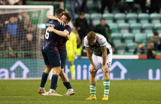 Hibs midfielder Chris Cadden is dejected as Ross County goalscorers Alex Iacovitti and Goerge Harmon celebrate at full-time. (Photo by Ross Parker / SNS Group)