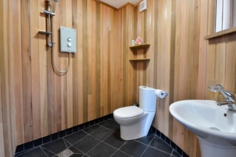 The luxurious cedar-panelled shower room comes complete with slate floor and underfloor heating.