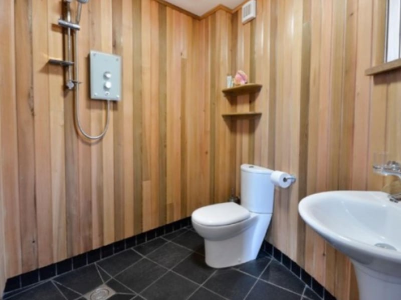 The luxurious cedar-panelled shower room comes complete with slate floor and underfloor heating.