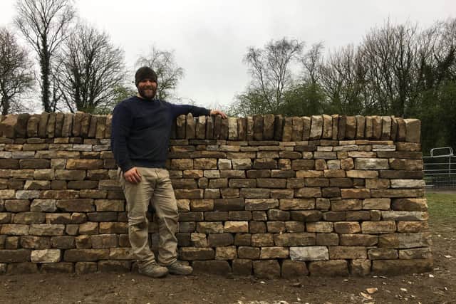 Martin Tyler standing next to one of his dry stone walling projects picture: supplied