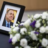 A photograph of Alex Salmond and flowers alongside a book of condolence in his memory. PIC: Jane Barlow/PA Wire