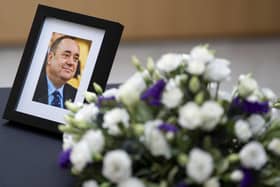 A photograph of Alex Salmond and flowers alongside a book of condolence in his memory. PIC: Jane Barlow/PA Wire