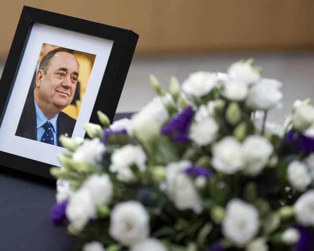 A photograph of Alex Salmond and flowers alongside a book of condolence in his memory. PIC: Jane Barlow/PA Wire
