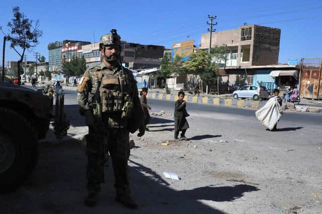 An Afghan security force personnel stands guard along the roadside in Herat on August 12