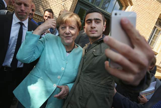 Angela Merkel poses for a selfie with Anas Modamani, from Syria, during a visit to a shelter for migrants and refugees in Berlin in 2015 (Picture: Sean Gallup/Getty Images)