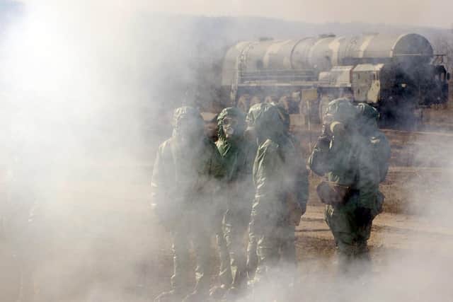 Russian soldiers wear chemical protection suits as they stand next to a model of a Russian Topol intercontinental ballistic missile during a training session (Picture: Natalia Kolesnikova/AFP via Getty Images)