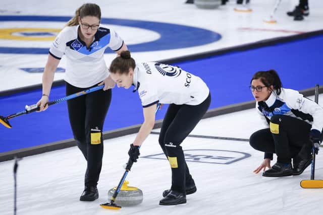Scotland skip Eve Muirhead, right, makes a shot as lead Lauren Gray, left, and second Jen Dodds sweep against Denmark. Picture: Jeff McIntosh/The Canadian Press via AP