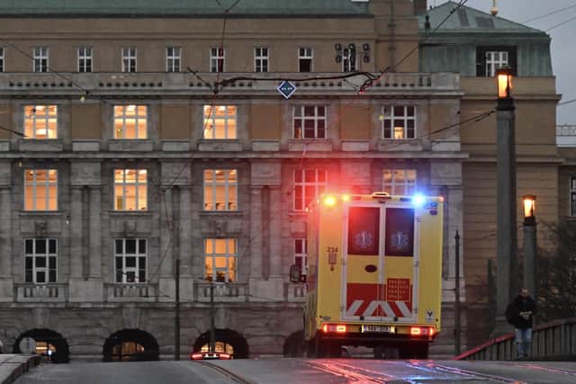 An ambulance drives over a bridge towards the Charles University in central Prague, where Czech police said a shooting in a university building in central Prague has left "dead and wounded people".