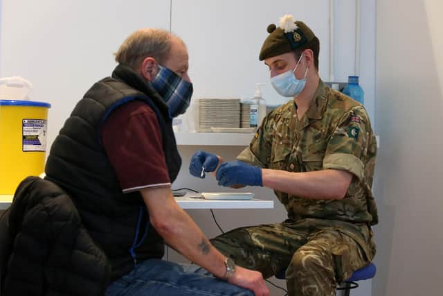 Derek Fraser from Edinburgh receives an injection of a coronavirus vaccine from military doctor Captain Robert Reid from 3 Medical Regiment who are assisting with the vaccination programme at the Royal Highland Showground near Edinburgh. Picture date: Thursday February 4, 2021.