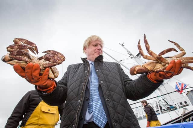 Boris Johnson holds crabs caught on the Carvela at Stromness Harbour during a visit to Scotland (Picture: Robert Perry/PA Wire)