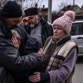 Relatives of a civilian man exhumed from his garden in Gostomel village, Kyiv region, on Tuesday comfort each other (Picture: Fadel Senna/AFP via Getty Images)