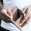 Someone looks at an empty wallet