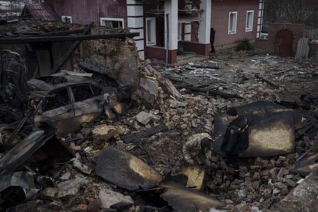 A Ukrainian firefighter and serviceman inspect a damaged house following a Russian drone attack in the village of Stari Bezradychi, Kyiv region, Ukraine, Monday, Dec. 19, 2022. (AP Photo/Felipe Dana)