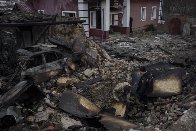 A Ukrainian firefighter and serviceman inspect a damaged house following a Russian drone attack in the village of Stari Bezradychi, Kyiv region, Ukraine, Monday, Dec. 19, 2022. (AP Photo/Felipe Dana)