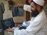 Mostaqim with x-ray images of the injuries he sustained in a suicide bomb attack.
