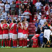 Denmark's players form a protective shield around Christian Eriksen as he receives medical attention. Picture: SNS