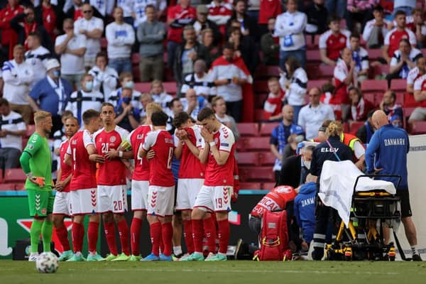 Denmark's players form a protective shield around Christian Eriksen as he receives medical attention. Picture: SNS
