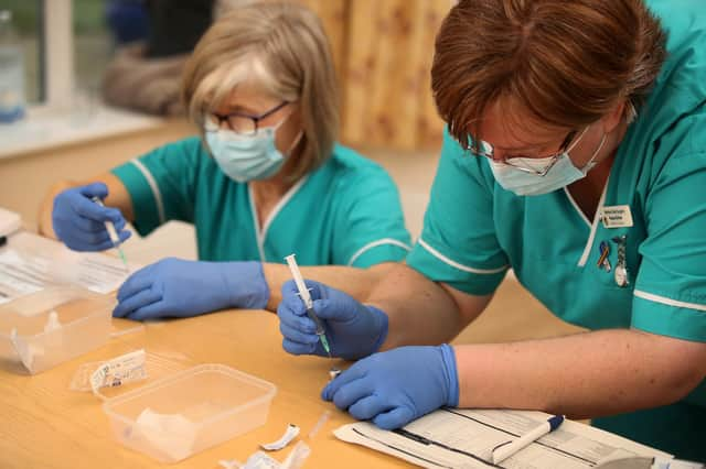 Health care assistant Paula Kirlew (right) and Nurse Helen Abbatt (left) prepare the BioNTech/Pfizer Covid-19 vaccine for doctors to administer.