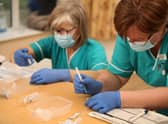 Health care assistant Paula Kirlew (right) and Nurse Helen Abbatt (left) prepare the BioNTech/Pfizer Covid-19 vaccine for doctors to administer.