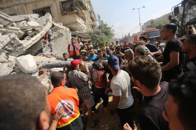 Palestinian emergency services and local citizens search for victims in buildings destroyed during Israeli air raids in the southern Gaza Strip The UN agency UNRWA, or the Relief and Works Agency for Palestine Refugees, has said the initial aid deliveries have been a "drop in the ocean" of what is needed. (Photo by Ahmad Hasaballah/Getty Images)