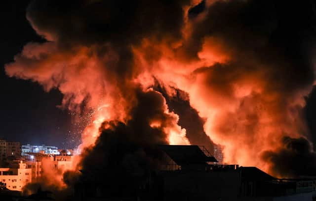 Explosions light up the night sky above buildings in Gaza City as Israeli forces shell the Palestinian enclave