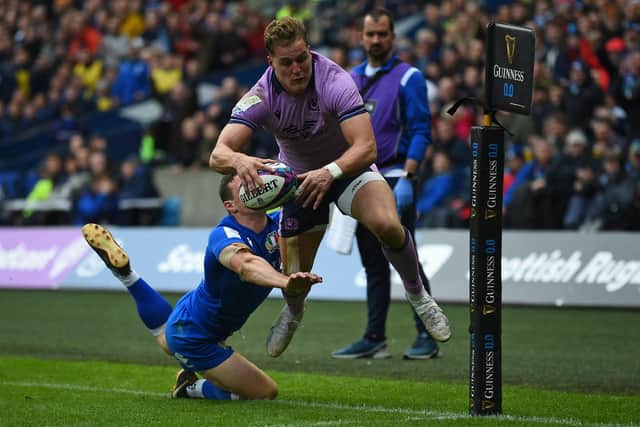 Scotland's wing Duhan van der Merwe scores their first try under pressure from Italy's fly-half Paolo Garbisi during the Six Nations clash at BT Murrayfield.