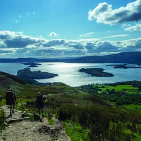 Green direction: hikers walk a trail above Loch Lomond, but the majority of tourism in Scotland still depends on fossil-fuelled transport.