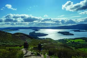 Green direction: hikers walk a trail above Loch Lomond, but the majority of tourism in Scotland still depends on fossil-fuelled transport.
