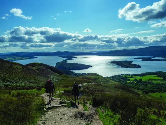 Green direction: hikers walk a trail above Loch Lomond, but the majority of tourism in Scotland still depends on fossil-fuelled transport.