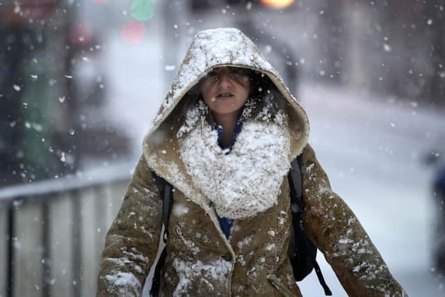 A woman makes her way through a snow flurry (Picture: Christopher Furlong/Getty Images)