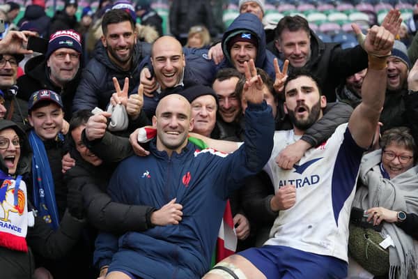 France's scrum-half Maxime Lucu (C) and France's flanker Charles Ollivon (R) celebrate with fans after beating Scotland.