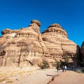 Tourists exploring AlUla's rock formations and canyons.