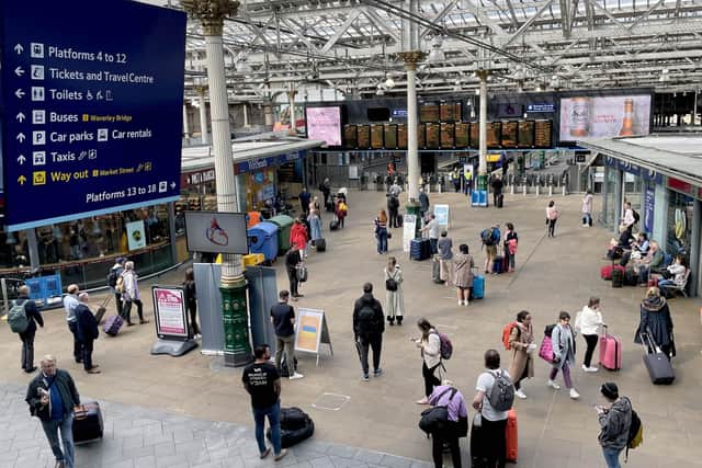 Passengers are shown here at Edinburgh Waverley station. Ministers are being urged to review the costs of travelling by public transport as part of efforts to cut car journeys. Picture: PA