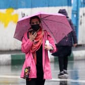 An Iranian woman walks in the street on a rainy day in the capital Tehran, on the day Iran has said it has scrapped its morality police after more than two months of protests triggered by the death of Mahsa Amini following her arrest for allegedly violating the country's strict female dress code.