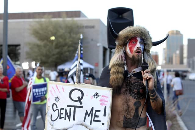 A believer in the bizarre QAnon conspiracy theory speaks to a crowd of Donald Trump's supporters in Phoenix, Arizona (Picture: Dario Lopez-Mills/AP)