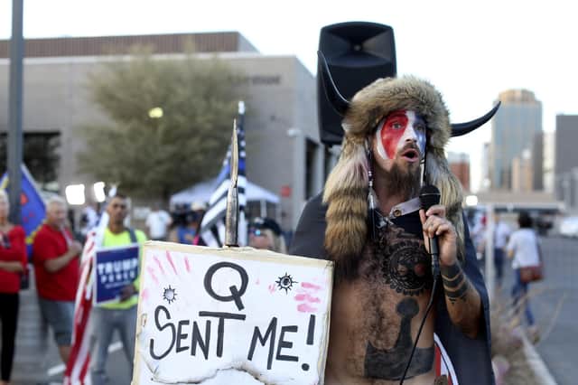 A believer in the bizarre QAnon conspiracy theory speaks to a crowd of Donald Trump's supporters in Phoenix, Arizona (Picture: Dario Lopez-Mills/AP)