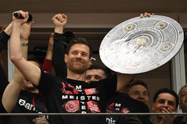 Xabi Alonso celebrates with a mock-up of the Bundesliga trophy after Bayer Leverkusen were crowned 2023-24 champions for the first time. (Photo by INA FASSBENDER/AFP via Getty Images)