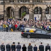 The hearse carrying the coffin of Queen Elizabeth II, draped with the Royal Standard of Scotland, passes the City Chambers on the Royal Mile. Picture: Jane Barlow/PA Wire