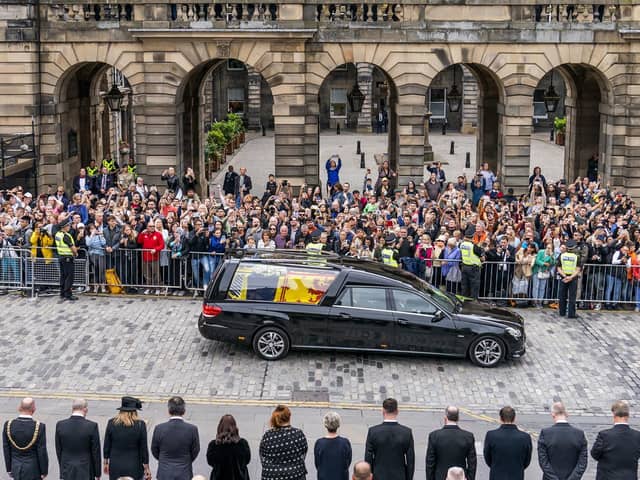 The hearse carrying the coffin of Queen Elizabeth II, draped with the Royal Standard of Scotland, passes the City Chambers on the Royal Mile. Picture: Jane Barlow/PA Wire