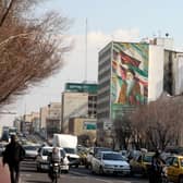 Motorists drive past a church on a main road in central Tehran with a portrait of the late founder of the Islamic republic Ayatollah Ruhollah Khomeini in the background.