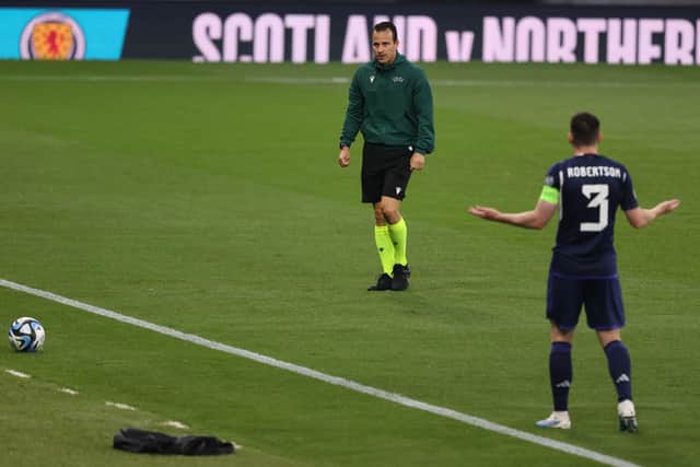 Scotland captainAndy Robertson gestures to referee Istvan Vad during a pitch inspection at Hampden.