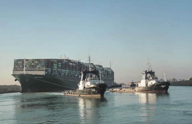 The Ever Given, a Panama-flagged cargo ship is pulled by Suez Canal tugboats, in the Suez Canal, Egypt as it is set free (Suez Canal Authority via AP).