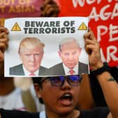 An activist holding a placard with portraits of US President Donald Trump and Israel's Prime Minister Benjamin Netanyahu at a rally condemning the US-Israeli strikes on Iran at a park in Quezon City, suburban Manila on March 2, 2026. (Picture: Ted ALJIBE / AFP via Getty Images)