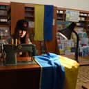 A young volunteer sews Ukrainian flags for the Ukrainian military at a library in western Ukrainian city of Lviv on April 2, 2022. Picture: YURIY DYACHYSHYN/AFP via Getty Images)