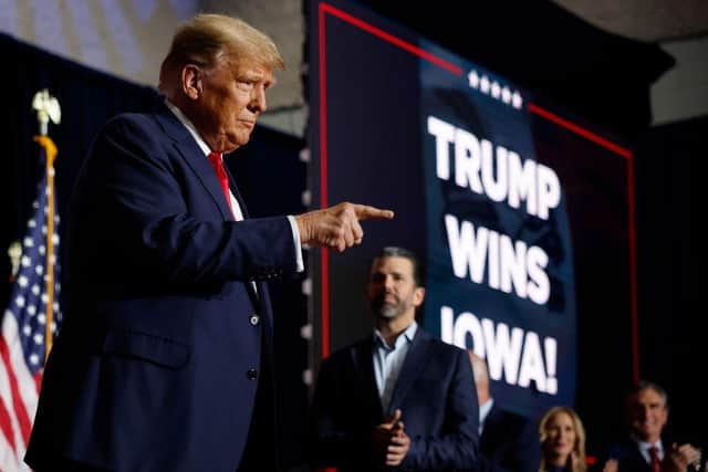 Republican presidential candidate, former US President Donald Trump, acknowledges supporters during his caucus night event at the Iowa Events Center in Des Moines, Iowa.