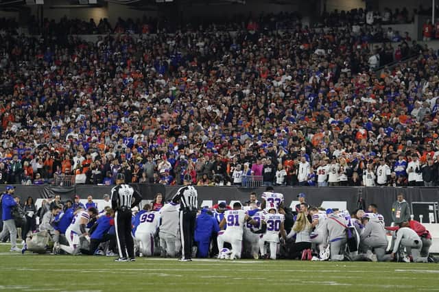 The Buffalo Bills players pray for teammate Damar Hamlin during the first half of an NFL football game against the Cincinnati Bengals.