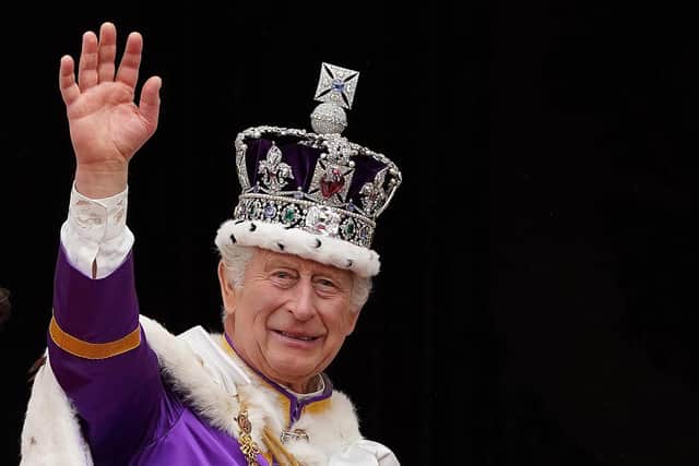 King Charles III wearing the Imperial state Crown, waves from the Buckingham Palace balcony after viewing the Royal Air Force fly-past in central London in May  last year after his coronation. Photo: STEFAN ROUSSEAU/POOL/AFP via Getty Images)