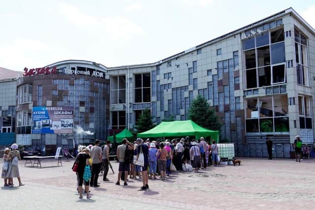 People wait in line at a food distribution organised by volunteers in the city of Mariupol.