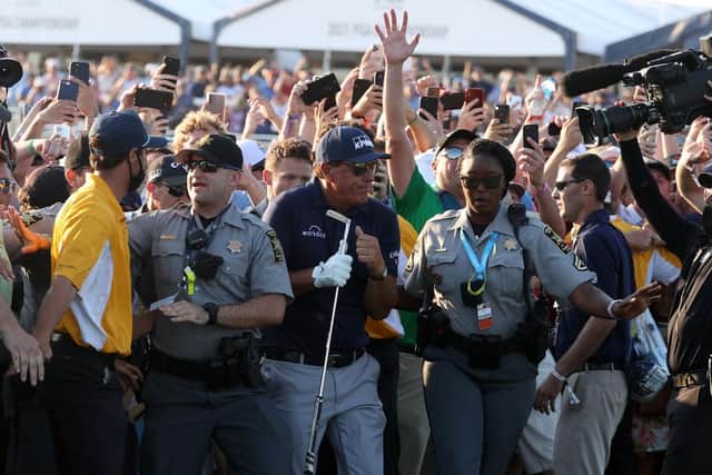 Phil Mickelson is assisted by security as he is followed up the 18th fairway by a gallery of fans in the final round of the 2021 PGA Championship at Kiawah Island. Picture: Patrick Smith/Getty Images.
