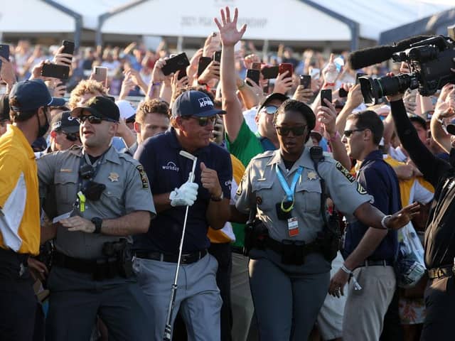 Phil Mickelson is assisted by security as he is followed up the 18th fairway by a gallery of fans in the final round of the 2021 PGA Championship at Kiawah Island. Picture: Patrick Smith/Getty Images.